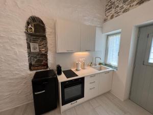 a kitchen with a black refrigerator and a sink at NeSi Cycladic Living in Ano Syros +35 photos