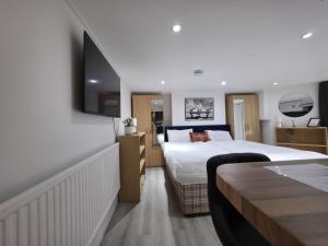a hotel room with a bed and a flat screen tv at Oxford Private Flat One in Oxford