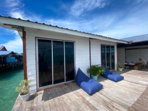 a deck with blue cushions on a house at Scuba Buddy Mabul Dive Lodge in Pulau Mabul 