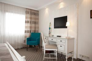 a hotel room with a desk and a tv at Hotel-Restaurant Arneggers Adler in Tiefenbronn