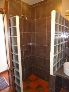 a shower with a glass door and a sink at Rendezvous Hostal in La Paz
