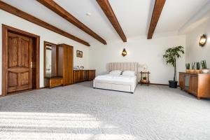 a bedroom with a white bed and wooden ceilings at Virkštininkų kurortas in Vydmantai +16 photos