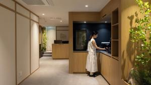 a woman standing at a counter in a kitchen at Anook Ryokan Hotel Suwon Ingye in Suwon
