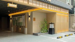 a entrance to a building with a plant next to it at Anook Ryokan Hotel Suwon Ingye in Suwon