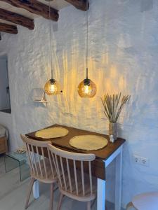 a dining room table with two chairs and two lights at NeSi Cycladic Living in Ano Syros