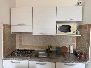 a kitchen with a sink and a microwave at Alloggio turistico La casetta di Piazza Roma in Bracciano