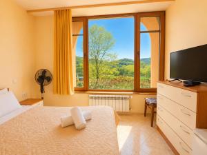 a bedroom with a bed and a large window at Комплекс Сборяна in Gramatikovo