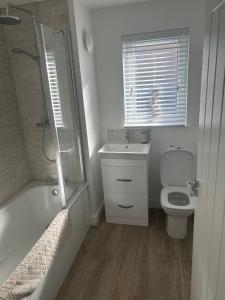 a bathroom with a toilet and a shower and a sink at House of Berry in EDI
