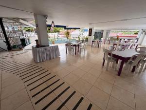 a restaurant with tables and chairs and a pool at Hotel La Popa Honda Tolima in Honda
