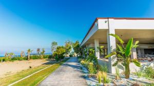 a building with a sidewalk next to a beach at Çenger Blue Collection Hotel Ultra All Inclusive in Manavgat