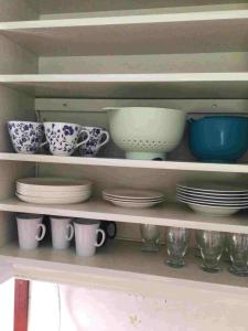 a shelf filled with plates and cups and bowls at Bagarstugan in Älvdalen