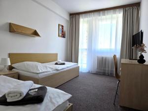 a hotel room with two beds and a window at Hotel Centrum Brno in Brno
