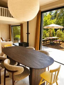 a dining room with a table and chairs and a large window at Huisje Mae in Nunspeet