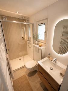 a bathroom with a toilet and a shower and a sink at Huisje Mae in Nunspeet