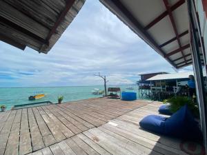 a wooden deck with a view of the ocean at Scuba Buddy Mabul Dive Lodge in Pulau Mabul 