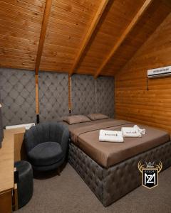 a bedroom with a bed and a chair in a room at Resort Maja e Zezë in Gnjilane +5 photos