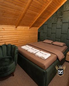 a bed and a chair in a room at Resort Maja e Zezë in Gnjilane