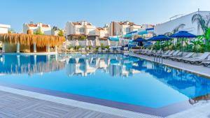 a swimming pool at a resort with chairs and umbrellas at Çenger Blue Collection Hotel Ultra All Inclusive in Manavgat