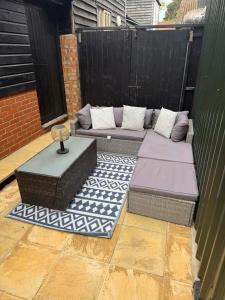 a patio with a couch and a table on a fence at The Old Dairy Accommodation in Tillingham +37 photos