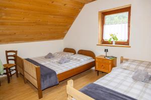 a bedroom with two beds and a window at Alpine Lodge Goška Ravan in Radovljica