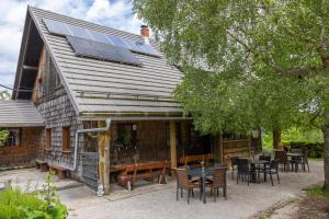 a house with a solar roof with tables and chairs at Alpine Lodge Goška Ravan in Radovljica +29 photos