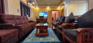 a living room with couches and a tv at JPR Heritage Villa in Pondicherry