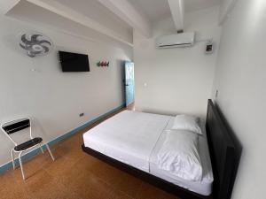 a bedroom with a bed and a chair in it at Hotel La Popa Honda Tolima in Honda