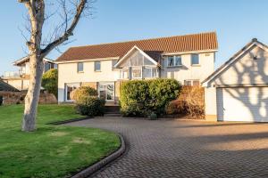 a house with a tree and a brick driveway at Homeview - Elie & Earlsferry in Elie