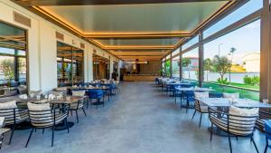 a restaurant with tables and chairs and large windows at Çenger Blue Collection Hotel Ultra All Inclusive in Manavgat