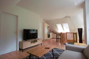 a living room with a flat screen tv and a couch at Ferienwohnung Hagge Quickborn bei Hamburg in Quickborn