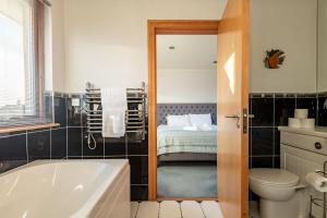 a bathroom with a tub and a toilet and a bed at Homeview - Elie & Earlsferry in Elie +53 photos