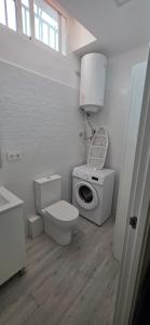 a white bathroom with a toilet and a sink at Estudio a 300 mts de la playa in Puebla de Farnals