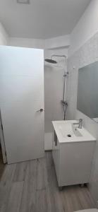 a white bathroom with a sink and a mirror at Estudio a 300 mts de la playa in Puebla de Farnals