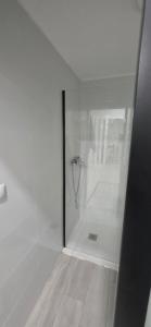a white bathroom with a shower with a glass door at Estudio a 300 mts de la playa in Puebla de Farnals