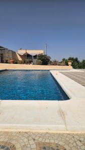 ein Schwimmbad mit blauem Wasser und ein Haus in der Unterkunft Finca Parella in Huércal-Overa