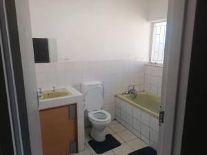 a bathroom with a sink and a toilet and a tub at Royal Oasis in Mahikeng +14 photos