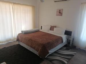a bedroom with a bed with a brown blanket at Royal Oasis in Mahikeng
