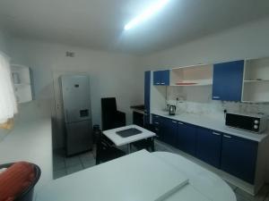 a kitchen with blue cabinets and a refrigerator at Royal Oasis in Mahikeng