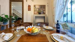 a table with a bowl of fruit and a bottle of wine at NEW Villa Cabo Roig Coco-Mat 2 in Playas de Orihuela