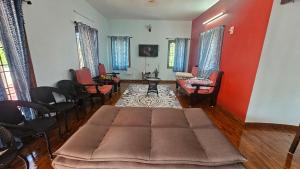 a living room with a couch in the middle of a room at La Parshwa Villa Maré in Mahabalipuram