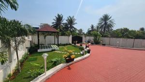 a backyard with a gazebo and a garden with flowers at La Parshwa Villa Maré in Mahabalipuram