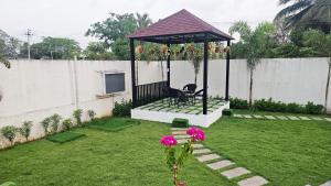 a gazebo with a chair in a yard at La Parshwa Villa Maré in Mahabalipuram +13 photos