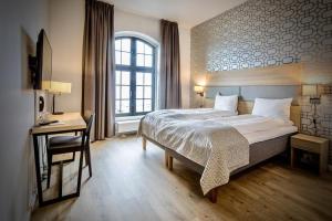 a bedroom with a bed and a desk and a window at Thon Hotel Victoria Hamar in Hamar +75 photos