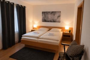 a bedroom with a bed with two lamps and a chair at Messeappartementhaus Bockenem direkt an der A7 in Bockenem