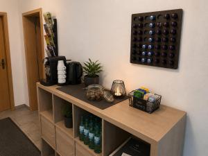 a wooden cabinet with a bunch of wine bottles on it at Messeappartementhaus Bockenem direkt an der A7 in Bockenem