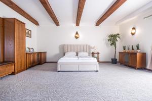 a bedroom with a white bed and wooden furniture at Virkštininkų kurortas in Vydmantai