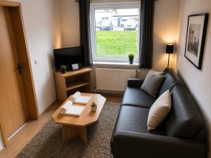 a living room with a couch and a coffee table at Messeappartementhaus Bockenem direkt an der A7 in Bockenem