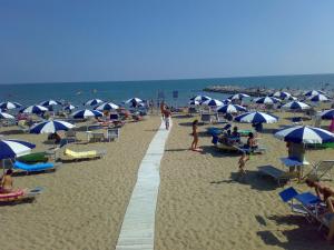 a group of people on a beach with umbrellas at Hotel Playa Blanca in Duna Verde