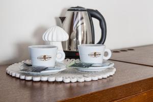 two coffee cups sitting on top of a table at Virkštininkų kurortas in Vydmantai