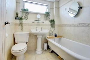 a bathroom with a toilet and a sink and a tub at Nordic Spa House in Brandon +24 photos